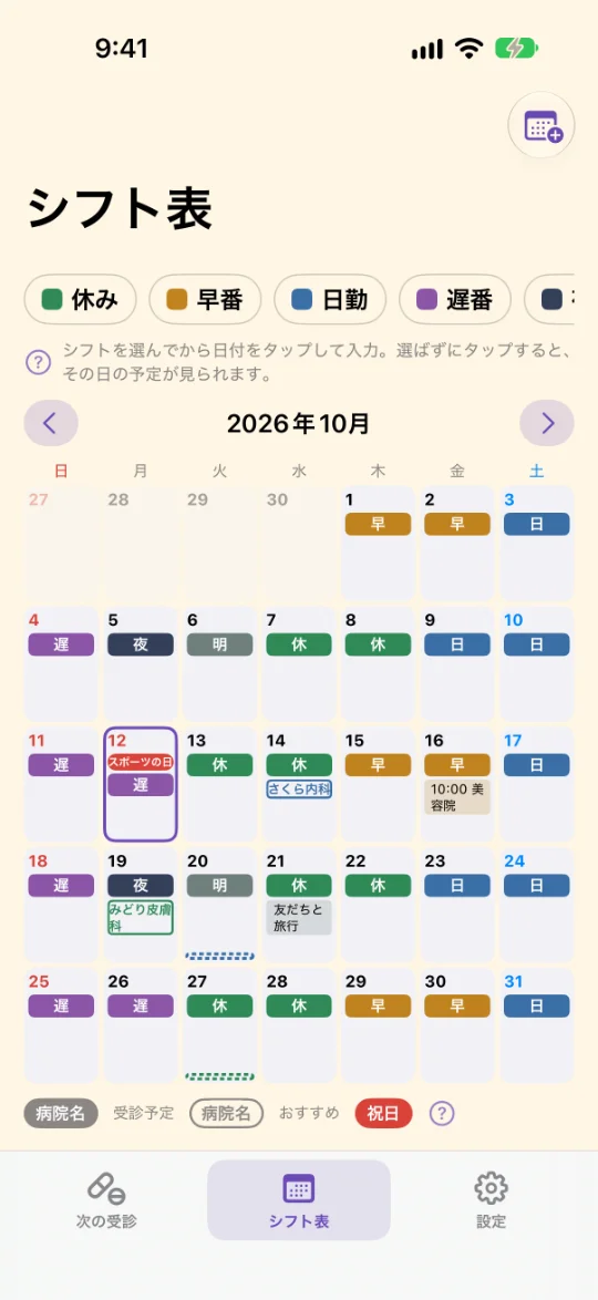 「シフト表」の画面。休み・早番・日勤・遅番などのシフトを選ぶボタンと2026年10月のカレンダー。日付ごとにシフト、受診のおすすめ日の病院名、自分の予定、祝日（スポーツの日）の赤い札、薬の最終日の点線